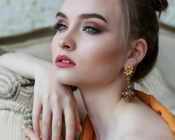 Stunning close-up portrait of a woman with elegant makeup and jewelry, epitomizing modern fashion and beauty.